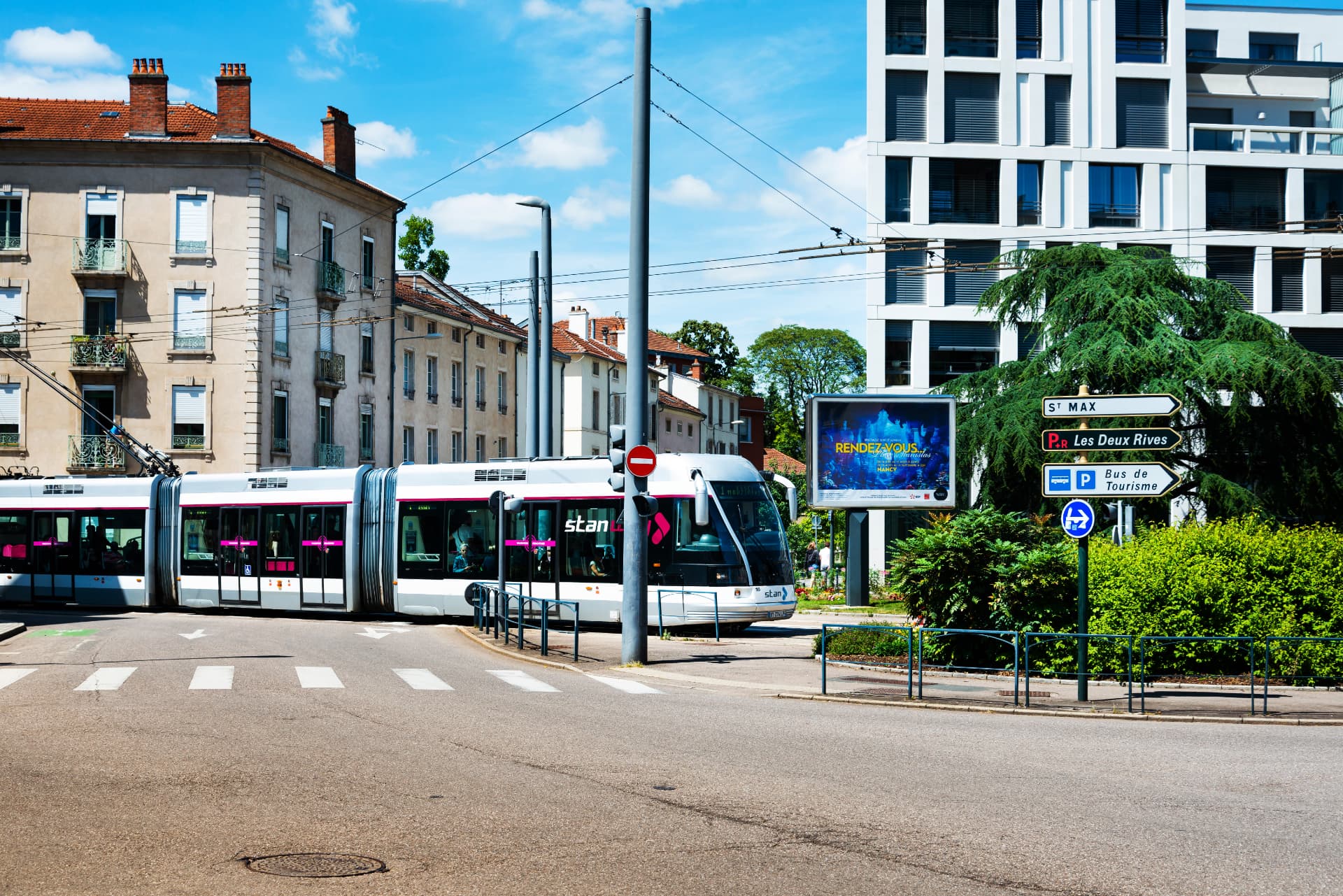 Straßenbahn an einer städtischen Kreuzung mit historischen und modernen Gebäuden