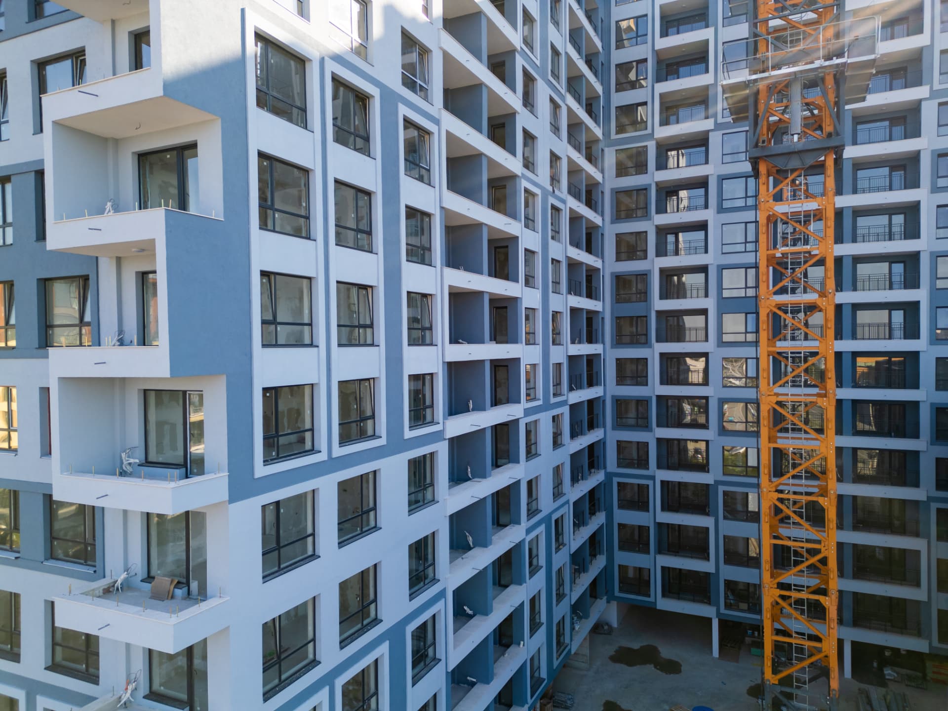 Neubaustelle eines Mehrfamilienhauses mit gelbem Turmdrehkran